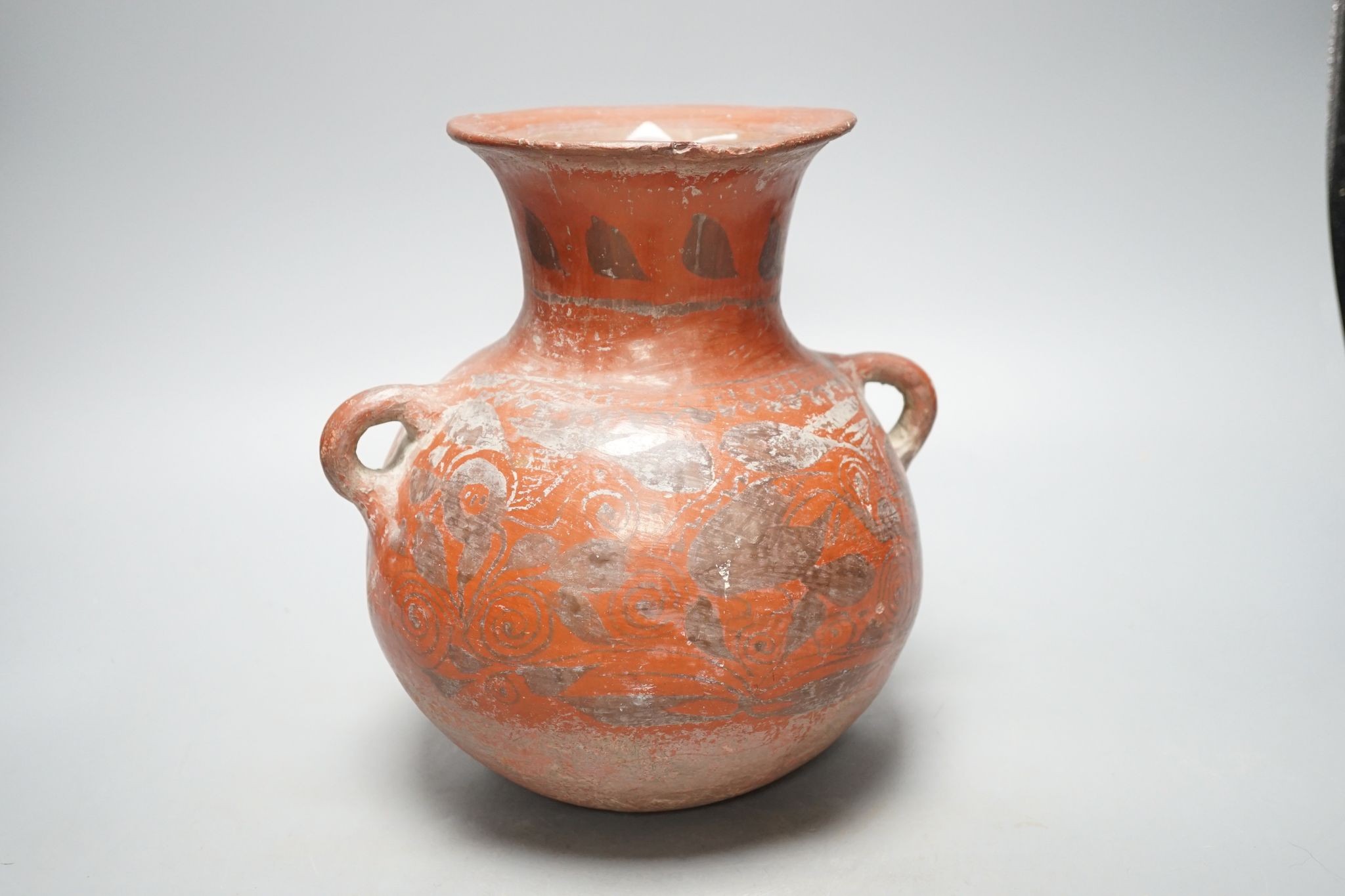 A pre-Columbian black and red pigment decorated two handled pot 25cm